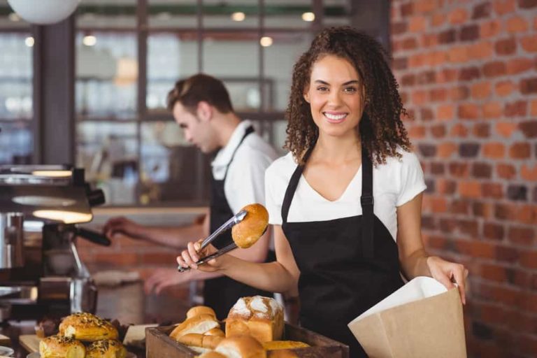 an image of a motivated restaurant employee smiling while working