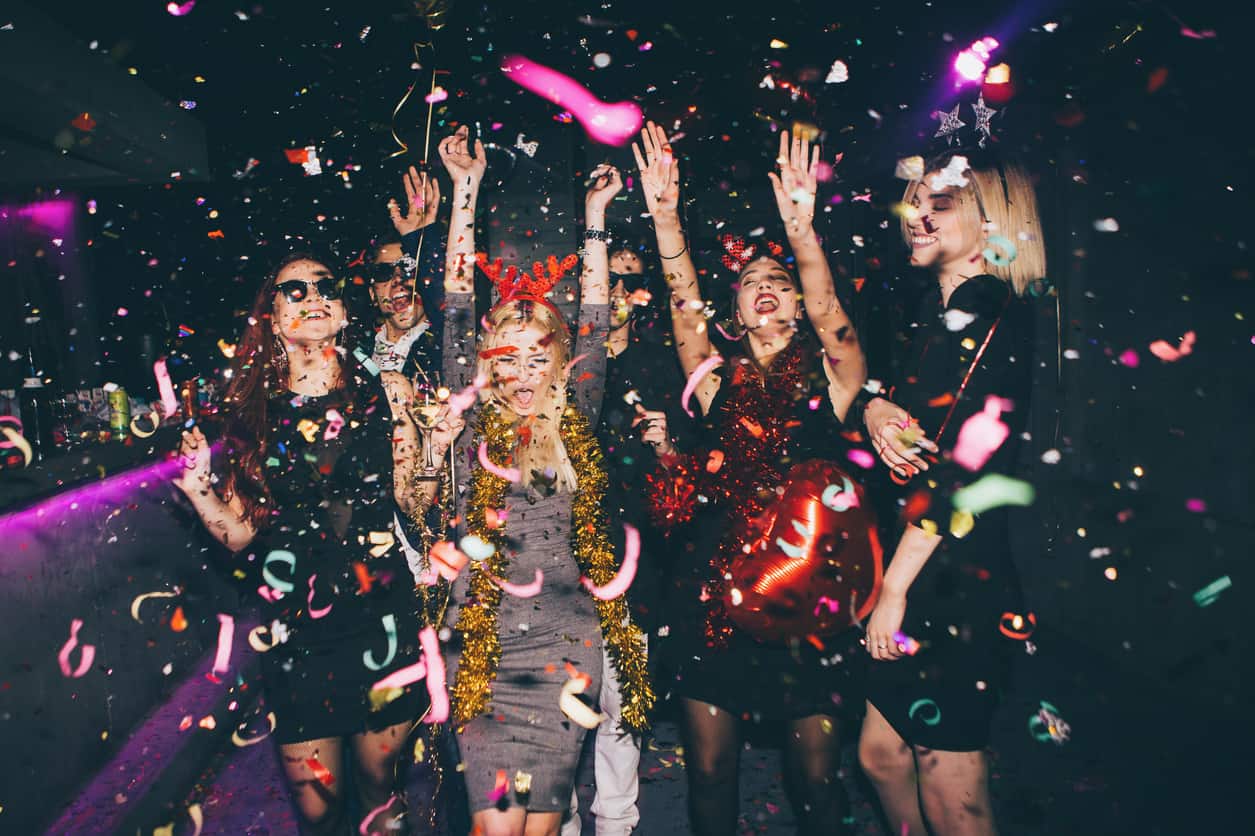 Group of friends having fun for new year's eve in a club. Drinking and dancing together