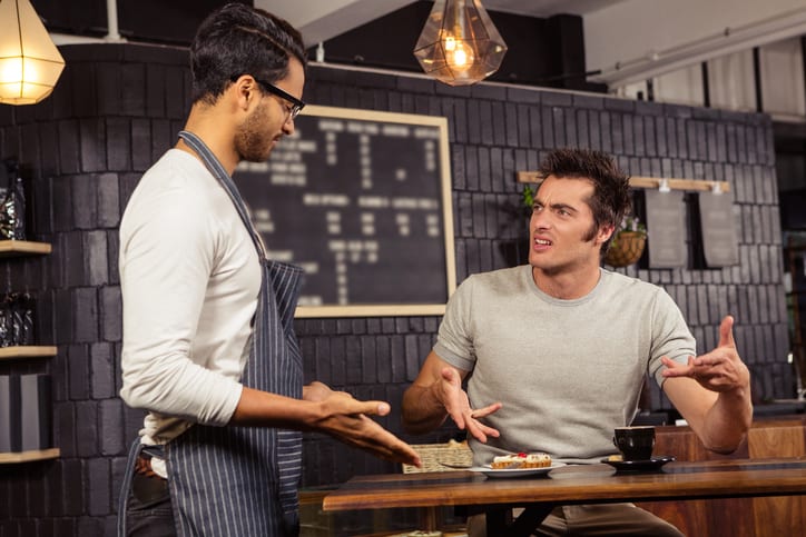Waiter and customer having a discussion in a bar
