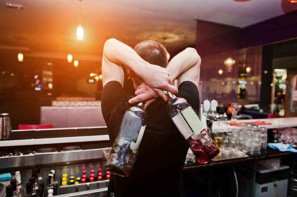 image of bartender juggling drinks.