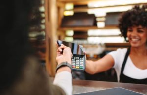 Customer making wireless or contactless payment using smartphone. Cashier accepting payment over nfc technology. Concept of using mobile to pay at pos in restaurant. Customer making wireless or contactless payment using smartphone. Cashier accepting payment over nfc technology. Concept of using mobile to pay at pos in restaurant.
